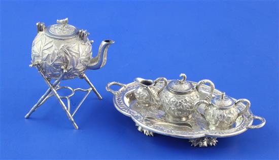 An early 20th century Chinese silver miniature four piece tea set, a similar two handled tray and a tea kettle on stand,